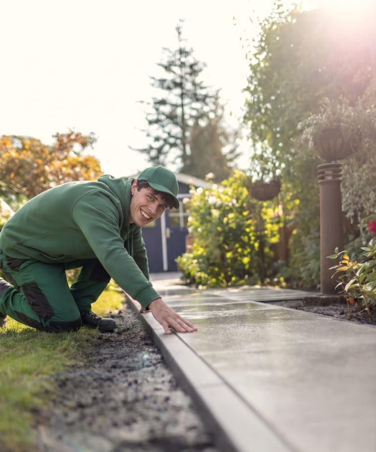 Gärtner setzt Randsteine an einem neuen Plattenweg
